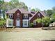 Charming two-story brick home with a well-maintained lawn and mature trees at 4909 Farm Valley Ne Dr, Woodstock, GA 30188