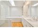 Bright bathroom featuring double vanity, soaking tub, glass shower, hardwood floors and skylight at 9062 Selborne Ln, Palmetto, GA 30268