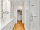 Bathroom featuring double vanity, glass shower, hardwood floors, and storage at 9062 Selborne Ln, Palmetto, GA 30268