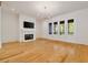Spacious living room with fireplace, hardwood floors, white trim, and direct access to porch through french doors at 9062 Selborne Ln, Palmetto, GA 30268