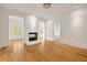 Bright living room featuring a brick fireplace, hardwood floors and white trim throughout at 9062 Selborne Ln, Palmetto, GA 30268