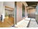 Exterior view of porch, leading into an open living room and kitchen area with beam ceilings and hardwood floors at 9062 Selborne Ln, Palmetto, GA 30268