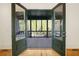 View through glass doors to screened in porch with stained wood ceiling, ceiling fans, and a view of the backyard at 9062 Selborne Ln, Palmetto, GA 30268