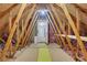 Spacious attic with exposed beams, flooring, and door at 115 Braided Blanket Blf, Johns Creek, GA 30022