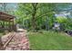 Serene backyard featuring a covered deck and mature trees, offering privacy and shade at 115 Braided Blanket Blf, Johns Creek, GA 30022