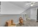 Attic bonus room featuring a rocking chair, chairs, and toy kitchen at 115 Braided Blanket Blf, Johns Creek, GA 30022