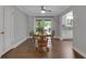 Bright dining room with wooden table and chairs, backyard access and view to the updated kitchen at 115 Braided Blanket Blf, Johns Creek, GA 30022