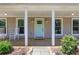 Welcoming front porch with rocking chairs, stylish lighting, and a charming front door at 115 Braided Blanket Blf, Johns Creek, GA 30022