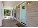 Close-up of a charming front porch with a turquoise door, rocking chairs, and inviting lights at 115 Braided Blanket Blf, Johns Creek, GA 30022