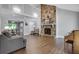 Bright living room with a stone fireplace, wood floors, and plenty of natural light at 115 Braided Blanket Blf, Johns Creek, GA 30022
