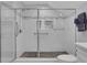 Modern walk-in shower with white tile, mosaic accents, and a frameless glass enclosure at 115 Braided Blanket Blf, Johns Creek, GA 30022