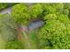 An aerial view of a compact home surrounded by dense, mature trees and natural landscaping at 1943 Scott Rd, Canton, GA 30115