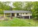 Rear exterior shot featuring covered patio, wood deck, large backyard, and partial fencing at 1943 Scott Rd, Canton, GA 30115