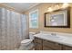 Well lit bathroom featuring tile floors, an updated mirror and vanity, and a shower with patterned curtain at 1943 Scott Rd, Canton, GA 30115