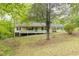 Inviting exterior view of the home featuring a covered porch and set amidst a serene, wooded landscape at 1943 Scott Rd, Canton, GA 30115