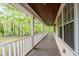 Inviting front porch with a wooden ceiling, offering a cozy space to relax and enjoy the surrounding nature at 1943 Scott Rd, Canton, GA 30115