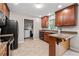 Galley kitchen featuring tile floors, granite countertops, stainless appliances, and laundry room access at 1943 Scott Rd, Canton, GA 30115