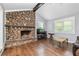 Bright living room showcasing a stunning stone fireplace, hardwood floors, and abundant natural light at 1943 Scott Rd, Canton, GA 30115
