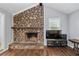 Bright living room with stone fireplace, dark wood floors, and neutral decor at 1943 Scott Rd, Canton, GA 30115