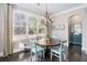 Sunlit breakfast nook boasts a round wood table, decorative chandelier, and large windows at 2005 Etris Manor Dr, Roswell, GA 30075