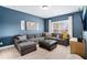 Blue living room with sectional couch, ottoman, and a large window at 2005 Etris Manor Dr, Roswell, GA 30075