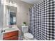 The powder room features a vanity with a cabinet, a toilet, and a shower with a black and white checkered curtain at 2582 Corey Park Dr, Loganville, GA 30052