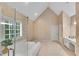 Elegant bathroom boasts vaulted ceiling, soaking tub, glass shower, and separate vanity at 3110 Royal Troon, Woodstock, GA 30189