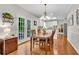Dining area with a chandelier and sliding door to a deck, adjacent to modern kitchen at 3110 Royal Troon, Woodstock, GA 30189