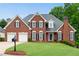 Charming brick home with a manicured lawn, two-car garage, and classic black shutters at 3110 Royal Troon, Woodstock, GA 30189
