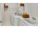 Functional laundry room with washer, dryer, utility sink, and storage shelves at 3110 Royal Troon, Woodstock, GA 30189