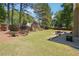 Spacious backyard with a patio area, lush lawn, mature trees, and privacy fence at 715 Aronson Lake Ct, Roswell, GA 30075