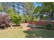 Spacious backyard with lush landscaping, mature trees and a white bench at 715 Aronson Lake Ct, Roswell, GA 30075