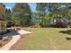 Lush backyard features a stone patio, outdoor seating, well-maintained lawn, and mature trees at 715 Aronson Lake Ct, Roswell, GA 30075