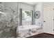 Modern bathroom with marble enclosed shower and separate soaking tub at 715 Aronson Lake Ct, Roswell, GA 30075