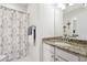 Bathroom with a granite countertop, vanity, mirror, shower and patterned shower curtain at 715 Aronson Lake Ct, Roswell, GA 30075