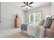 Cozy bedroom featuring carpeted floors, warm natural light from the windows and a ceiling fan at 715 Aronson Lake Ct, Roswell, GA 30075