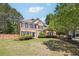Lovely brick home with manicured lawn and landscaping with mature trees surrounding the property at 715 Aronson Lake Ct, Roswell, GA 30075