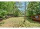 This is a wide backyard with a wooden fence and lots of trees and grass at 1423 Fairfield Sw Dr, Lilburn, GA 30047