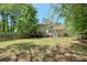 Wide backyard with wooden fence, grass and trees with a view of the house at 1423 Fairfield Sw Dr, Lilburn, GA 30047