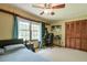 Bedroom featuring light-colored walls, a ceiling fan, carpeting, and lots of natural light at 1423 Fairfield Sw Dr, Lilburn, GA 30047