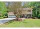 Suburban home with well-kept lawn, mature trees, and inviting curb appeal showing a two-car garage and front door at 1423 Fairfield Sw Dr, Lilburn, GA 30047