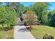 View of the front yard with a house, driveway, tree, and green landscaping at 1423 Fairfield Sw Dr, Lilburn, GA 30047