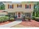 Charming two-story home featuring stone accents, a red front door, well-maintained landscaping, and bright red window shutters at 1423 Fairfield Sw Dr, Lilburn, GA 30047