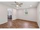 Bedroom with wood-look floors, ceiling fan, and open access to kitchen at 160 Oglesby Bridge Rd, Conyers, GA 30094