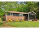 Charming ranch-style home with dark siding, brick base, screened porch and verdant surroundings at 160 Oglesby Bridge Rd, Conyers, GA 30094