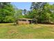 Charming ranch-style home boasts a brick facade, screened porch, and lush lawn surrounded by trees at 160 Oglesby Bridge Rd, Conyers, GA 30094