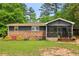 Cozy ranch style home featuring brick facade, dark siding, screened porch, and lush green front lawn at 160 Oglesby Bridge Rd, Conyers, GA 30094