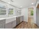 Bright kitchen with gray cabinetry, stainless dishwasher, and view to connecting room at 160 Oglesby Bridge Rd, Conyers, GA 30094