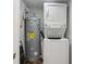 Laundry closet featuring a stackable washer/dryer set and a hot water tank at 160 Oglesby Bridge Rd, Conyers, GA 30094