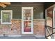 Inviting screened porch with brick siding, dark trim, and a glimpse of the home's interior at 160 Oglesby Bridge Rd, Conyers, GA 30094